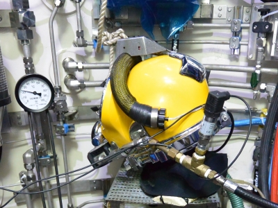 Diving helmet connected to breathing simulator during verification testing
